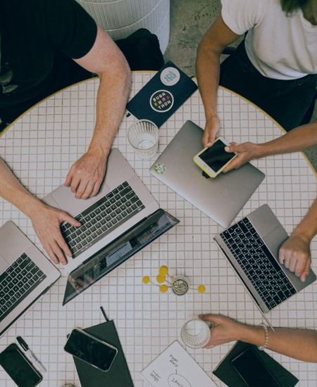 Overhead view of a team working with laptops and notes